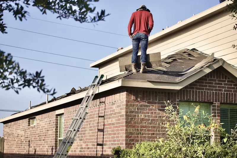 Professional roofer working on a residential roof in Elmo